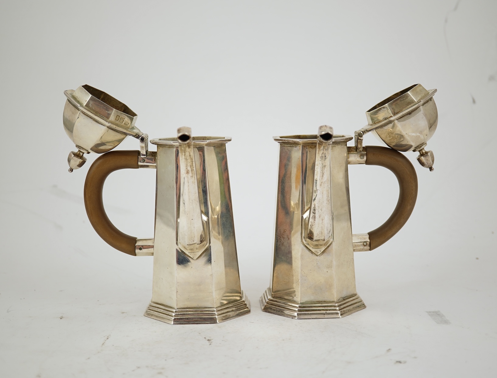 A pair of George V octagonal silver café au lait pots, by William Comyns & Sons Ltd